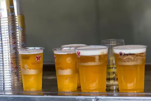 Fünf Bier in Plastikgläser mit dem Tomorrowland-Slogan stehen auf einem Metalltisch