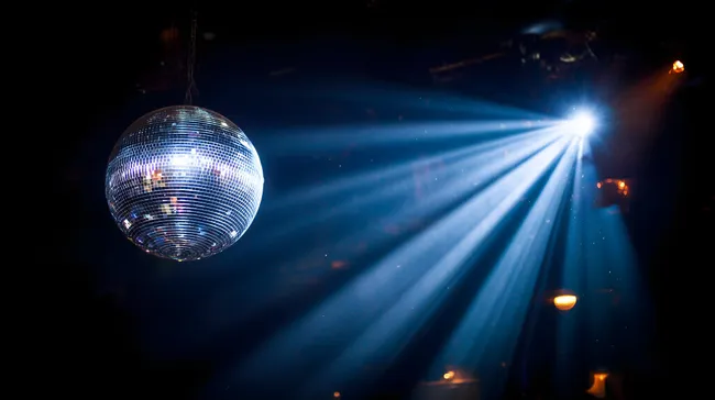 Funkensprühende Discokugel in dunkler Nacht