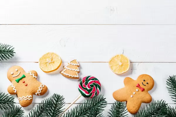 Funny gingerbread men with tree branches and candy