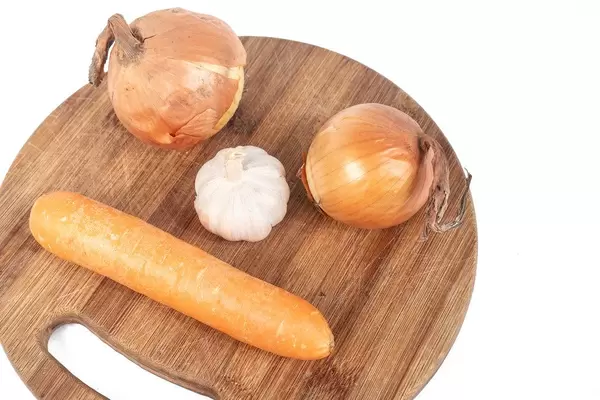 Funny image with Onion Garlic and Carrot on the wooden board (Flip 2019)