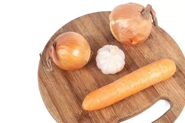 Funny image with Onion Garlic and Carrot on the wooden board