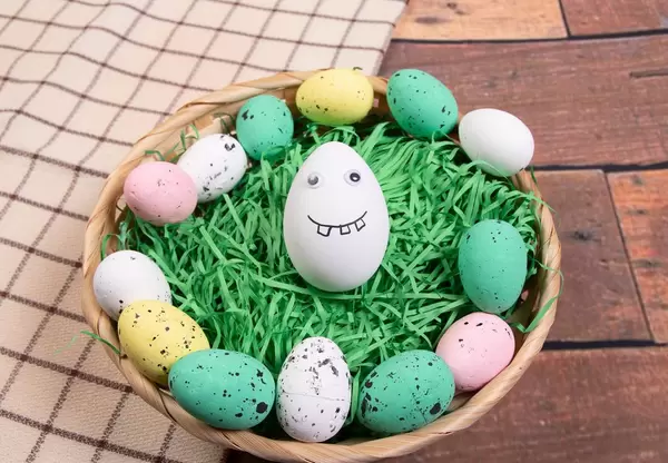 Funny painted Easter egg in a basket