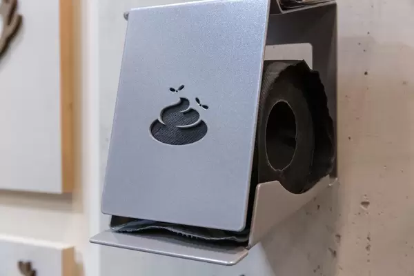 Funny toilet paper holder with motif in the form of poo and flies with black paper