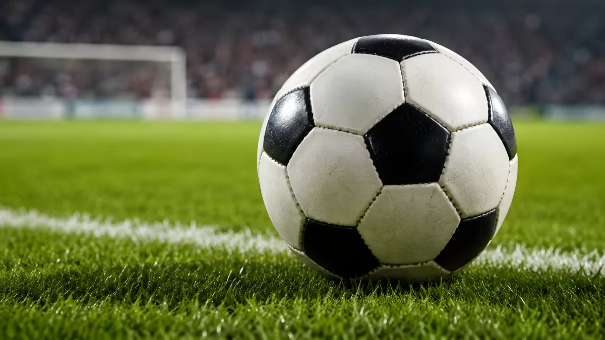 Fußball auf grünem Rasen vor einem Tor im Stadion