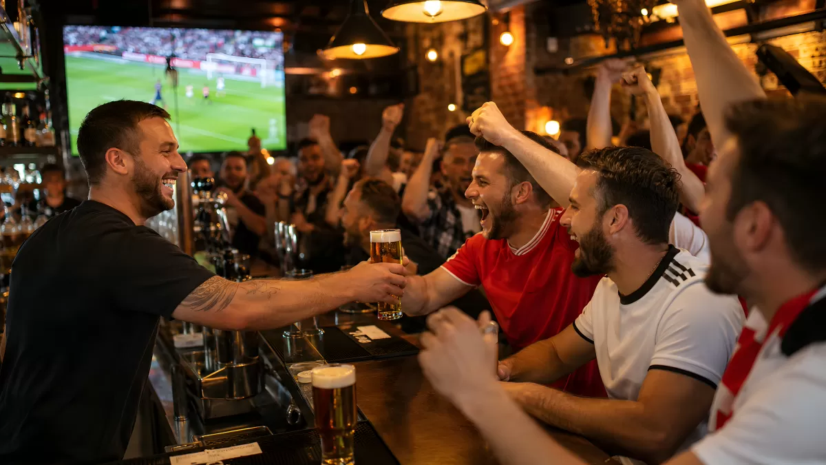 Fußballfans feiern Tor in belebter Sportkneipe