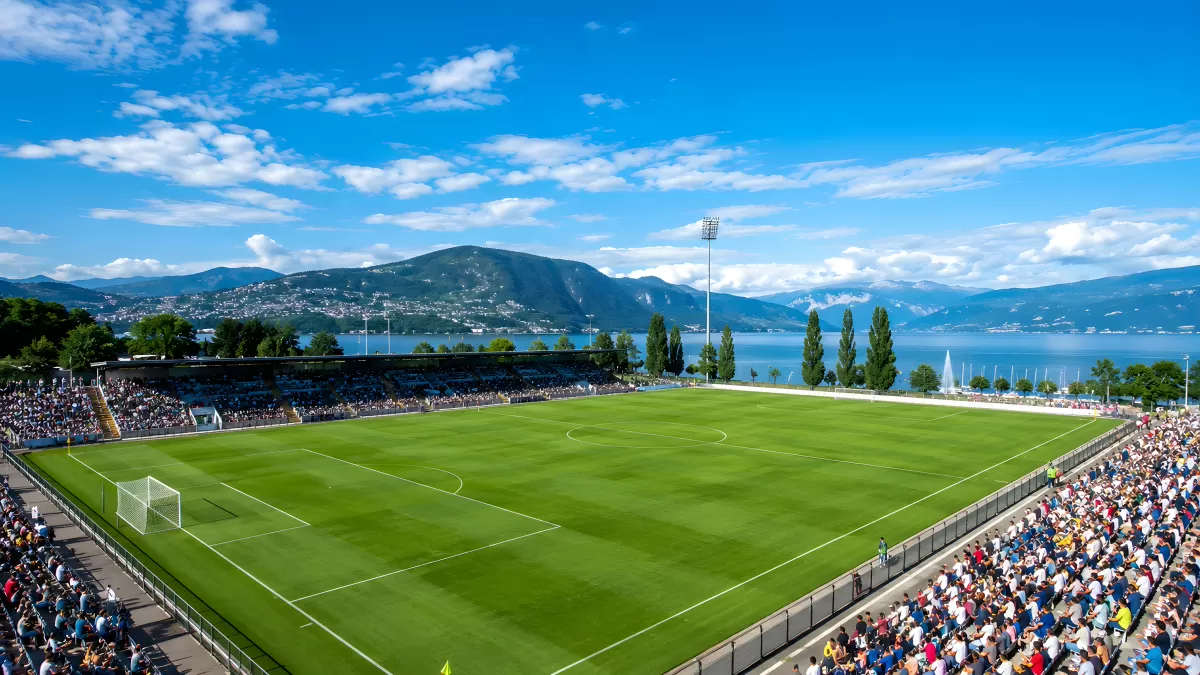 Fußballstadion mit Bergpanorama und Seeufer
