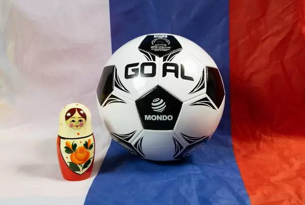 Fußball und eine Matrjoschkapuppe auf der russischen Flagge