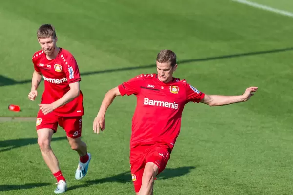 Fußballer Mitchell Weiser und Sven Bender laufen beim Fußballtraining über das Spielfeld