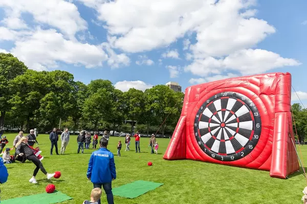 Fußballfans des 1. FC Kölns schießen auf den Stadionvorwiesen Fußbälle mit Klett an eine gigantische Zielscheibe nach dem Aufstiegsspiel