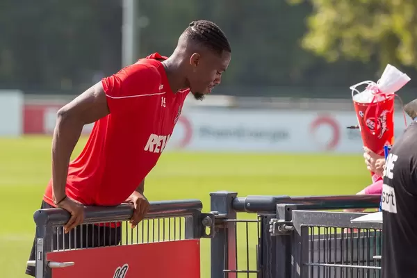 Fußballspieler Kingsley Ehizibue stützt sich nach dem Training auf einem Tor ab, um mit Fans zu reden