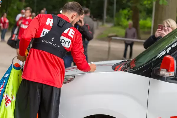 Fußballspieler signiert ein Auto