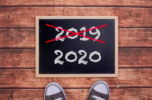 Füße vor einer Jahreszahltafel symbolisieren den Übergang und Eintritt in das Jahr 2020