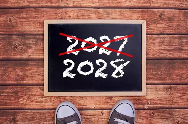 Füße vor einer Jahreszahltafel symbolisieren den Übergang und Eintritt in das Jahr 2028