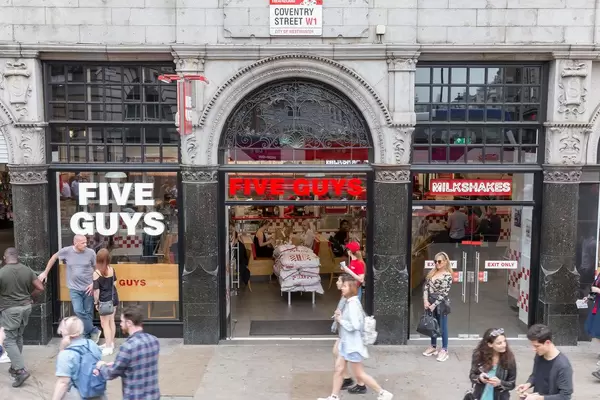 Fußgänger laufen an einem Five Guys Lokal vorbei