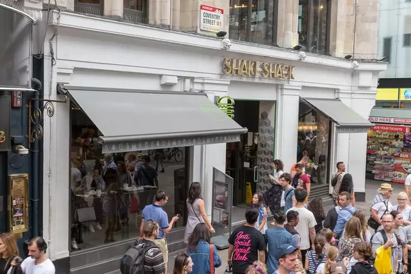 Fußgänger laufen an einem Shake Shack Lokal vorbei