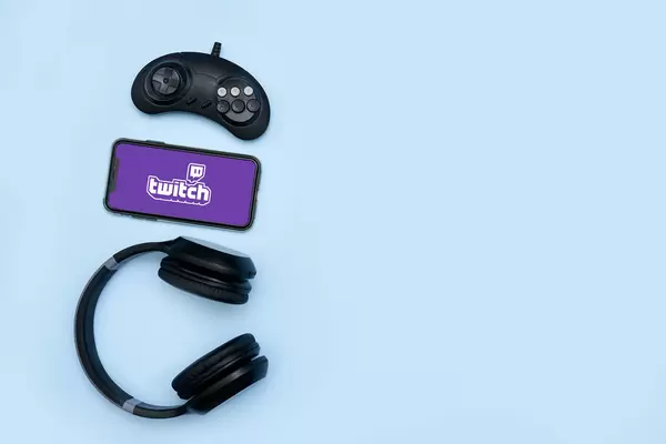Game controller, wireless headset and mobile phone with Twitch logo on the display