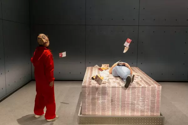 Games fair visitors lie on piles of money of Netflix TV Show Money Heist / La casa de papel at the Gamescom in Germany