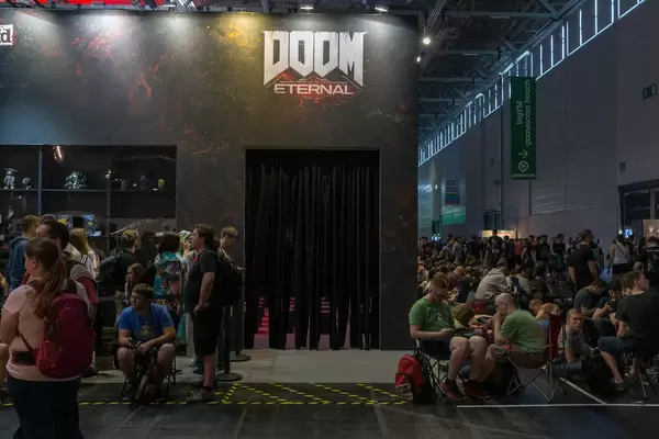 Games fair visitors waiting in line with camping chairs, to play Doom Eternal during Gamescom