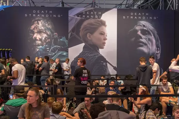 Gamescombesucher vor Plakaten zum Open World Action-Adventurespiel Death Stranding, von Kojima Productions