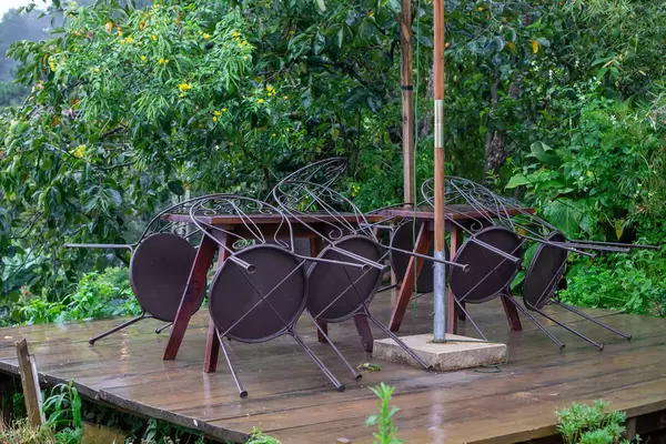 Garden Chairs leaning on Wooden Tables at an Outdoor Space of a Cafe