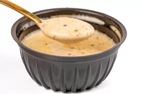 Garlic barbecue sauce in a spoon, close-up