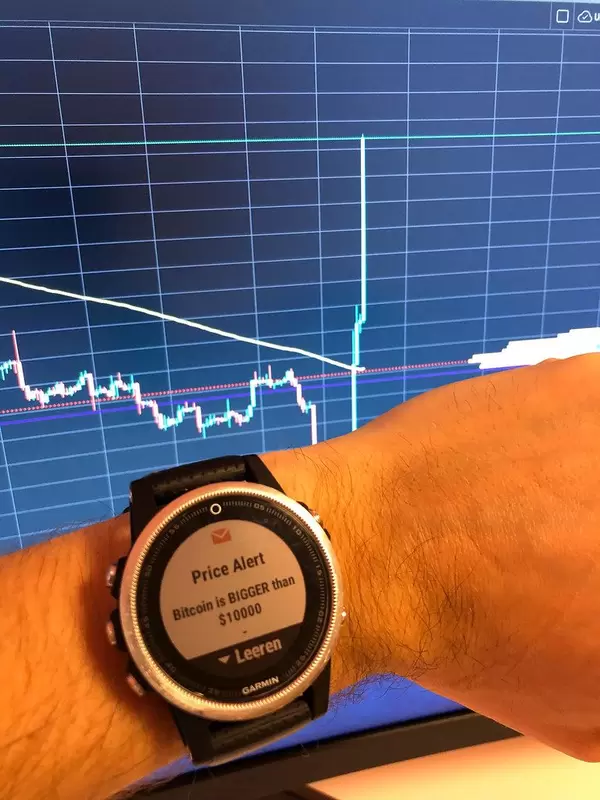 Garmin Smartwatch mit einkommender Benachrichtigung Bitcoin steigt über 10000$ mit Kurswert im Hintergrund