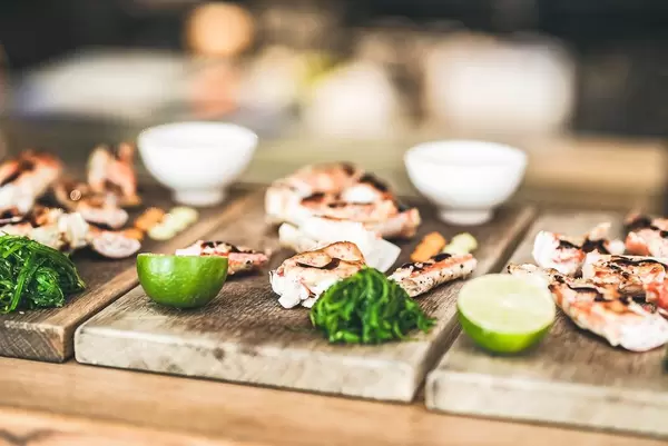 Garnelen-Snacks mit Limette, auf rustikalen Holzbrettchen