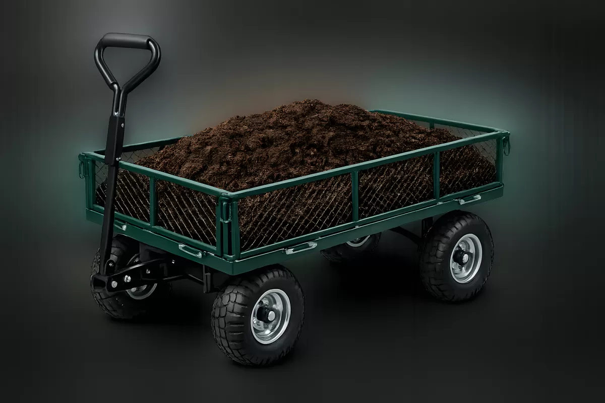 Gartenwagen mit Erde gefüllt auf dunklem Hintergrund