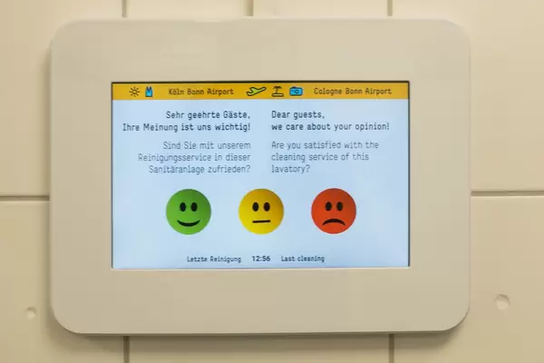 Gästeumfrage auf einem Tablet in der Toilette am Flughafen