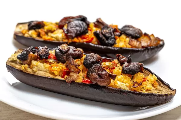 Gebackene Auberginenhälften mit Pilzen, Gemüse und Couscous überbacken