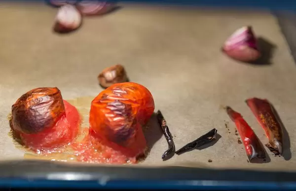 Gebackene, aufgeplatzte Tomaten im Backofen mit Zwiebeln und Chili