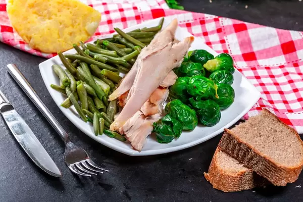 Gebackene Hähnchenbrust in Scheiben mit Rosenkohl und Spargel