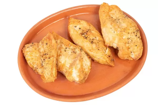 Gebackene Hähnchenbrustfilets auf einem Teller vor weißem Hintergrund