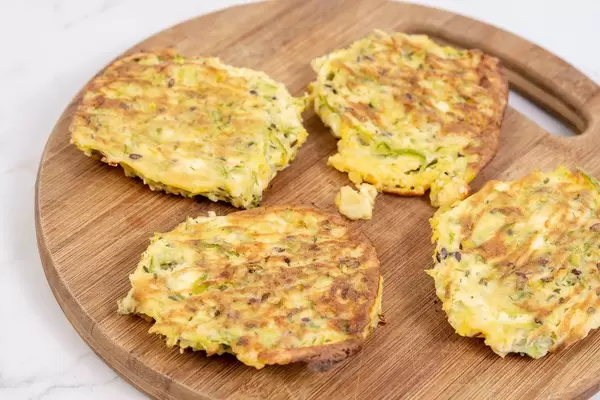 Gebackene Zucchini-Fleisch Küchlein auf rundem Holzschneidebrett