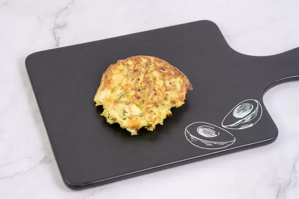 Gebackene Zucchini-Fleisch Küchlein auf schwarzem Schneidebrett