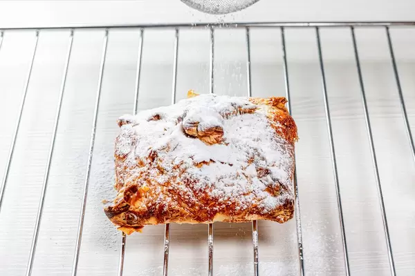 Gebackener Apfelstrudel mit Puderzucker, auf einem Backrost