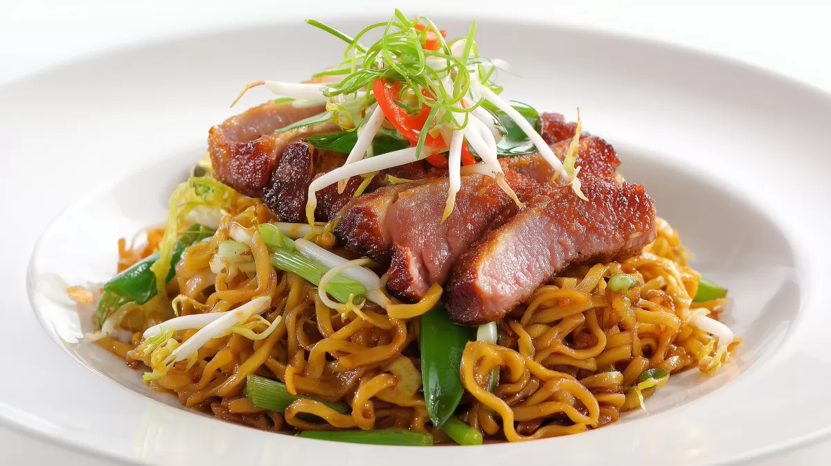 Gebratene Ente mit Bami Goreng auf weißem Teller