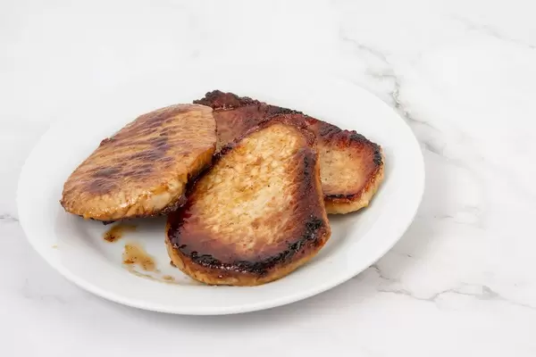 Gebratene Schweinekoteletts auf einem weißen Teller