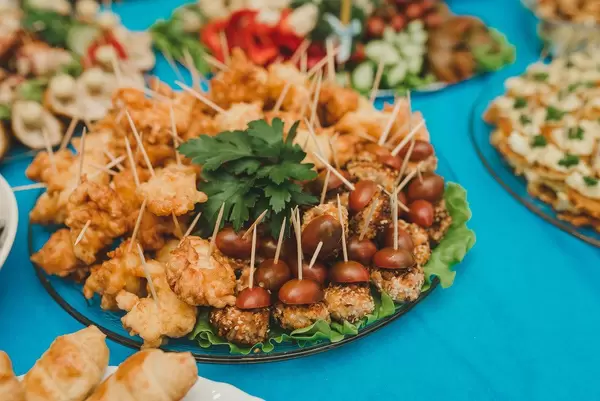 Gebratenes Huhn und Cherrytomaten auf einem Glasteller auf einem Hochzeitstisch