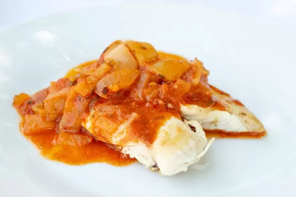 Gebratenes Hühnerfleisch mit Tomatensauce auf einem Teller