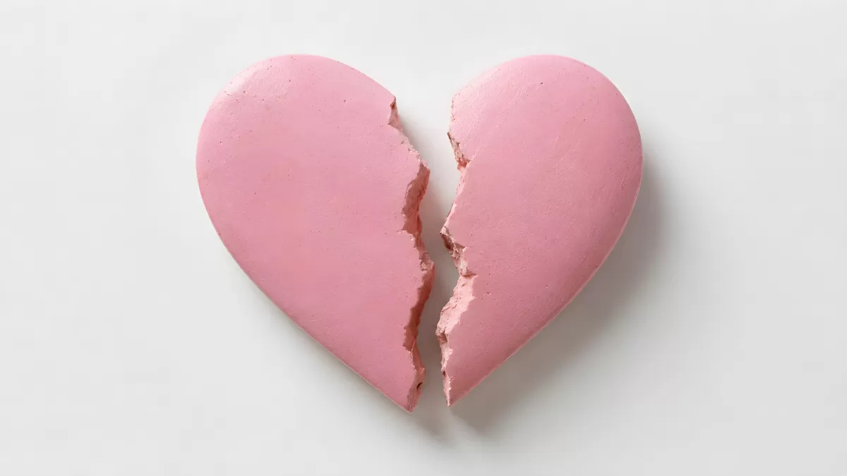 Gebrochenes rosa Herz aus Gips auf weißem Grund