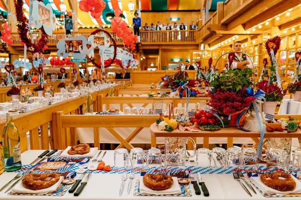 Gedeckte Tische mit Brezeln und Deko in der Augustiner Festhalle beim Oktoberfest in München
