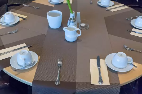 Gedeckter Tisch mit Kaffeetassen und Besteck