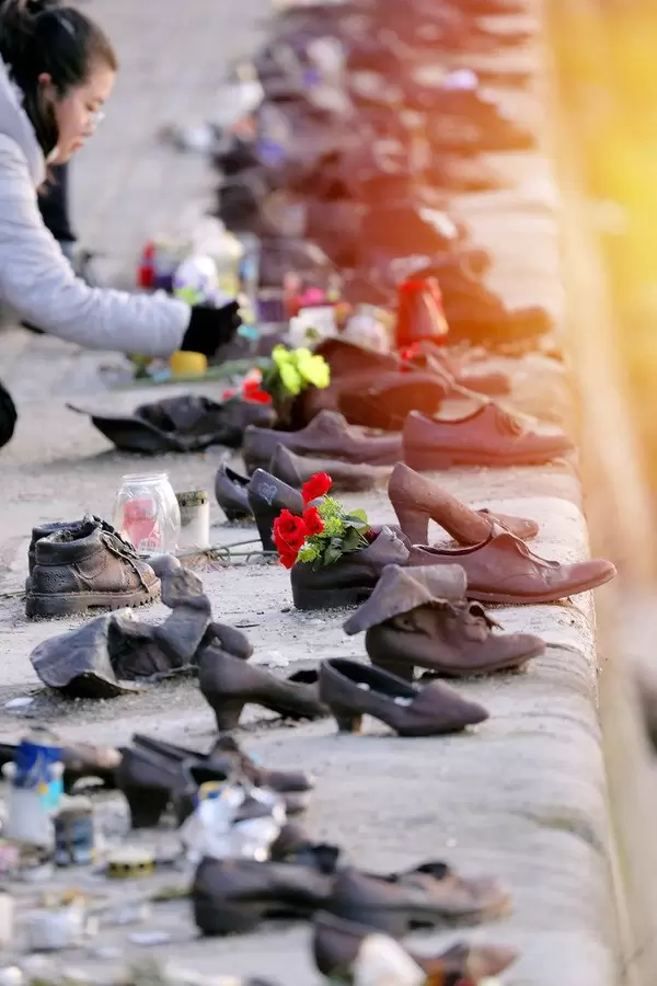 Gedenkstätte für die Judenermordung in Budapest: Mahnmal aus metallenen Schuhe am Donauufer mit Blumen