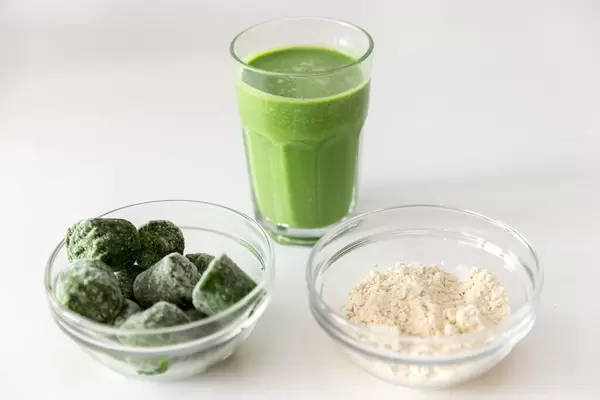 Gefrorener Spinat und weißes Mandelpulver:  Zutaten für ein grünes Proteingetränk für Sportler