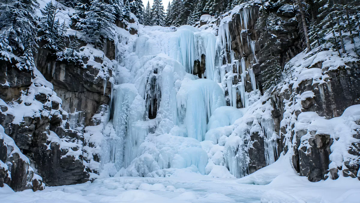 Gefrorener Wasserfall im winterlichen Bergwald