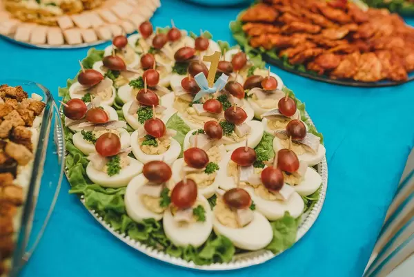 Gefüllte Eier mit Cherrytomaten und Petersilien auf einem Brett