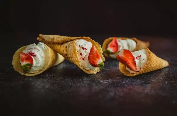 Gefüllte Eiscreme-Waffeln mit Sahne und Erdbeer-Viertel in Nahansicht