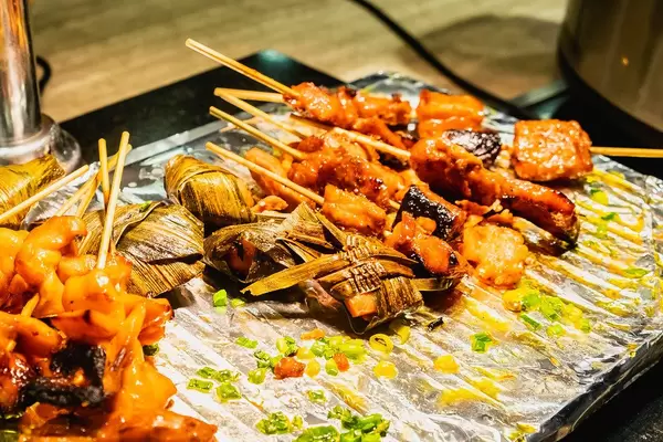 Gegrillte Huhn- und Schweinefleisch-Spieße auf Alufolie