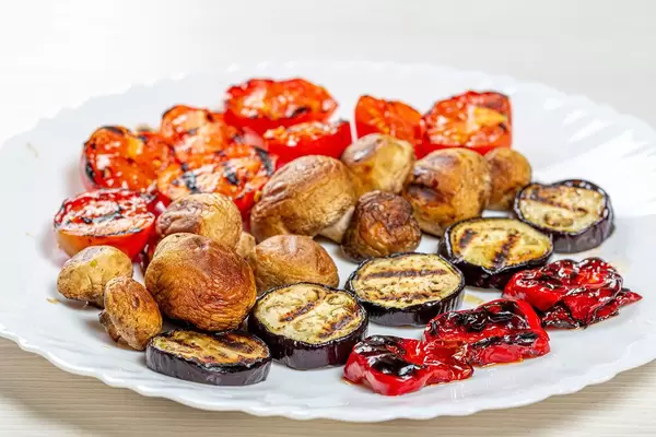 Gegrillte Tomaten, Paprika, Pilze und Auberginen, auf einem weißen Teller